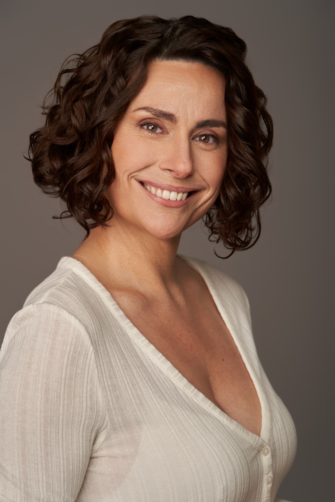 Retrato de casting de Begoña Álvarez sonriendo con blusa blanca